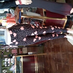 Black and Pink Heart Leggings with Playful Pattern and Form-Fitting Desi…